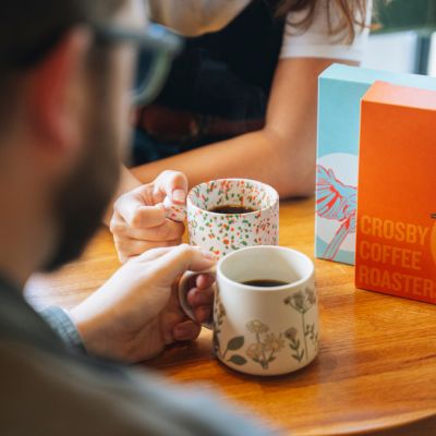 Two people drinking Arabica coffee in white mugs